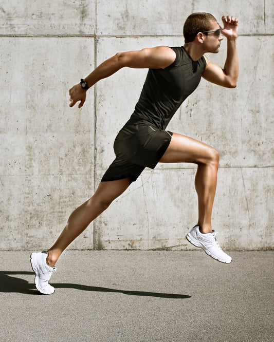 A man with white shoes running in a concrete arena