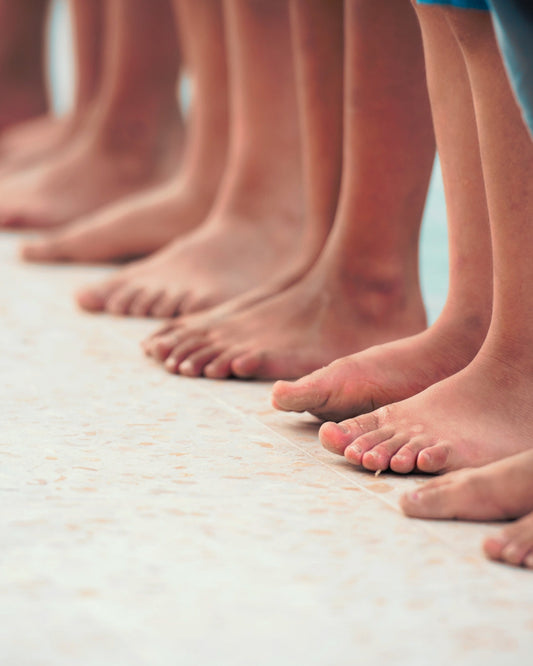 A close up of multiple people's bare feet and ankles 
