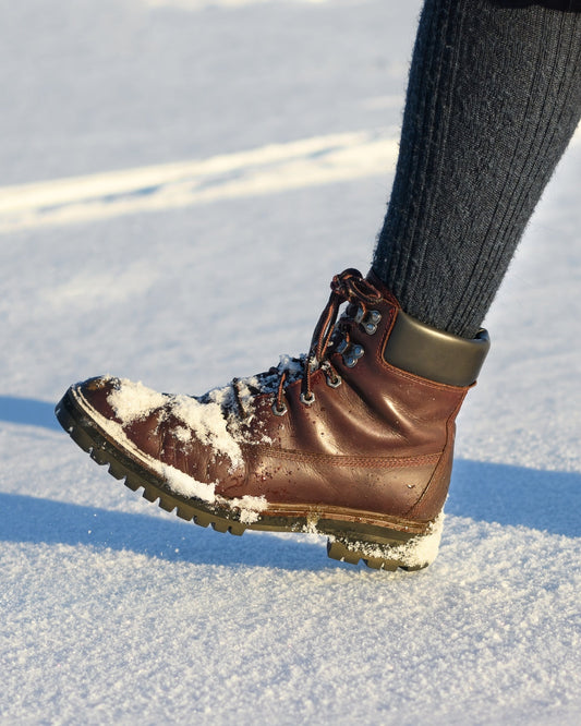Image of a person's boot taking a step in the snow
