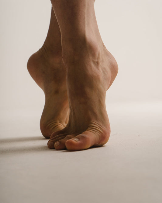 A person's feet standing on their toes
