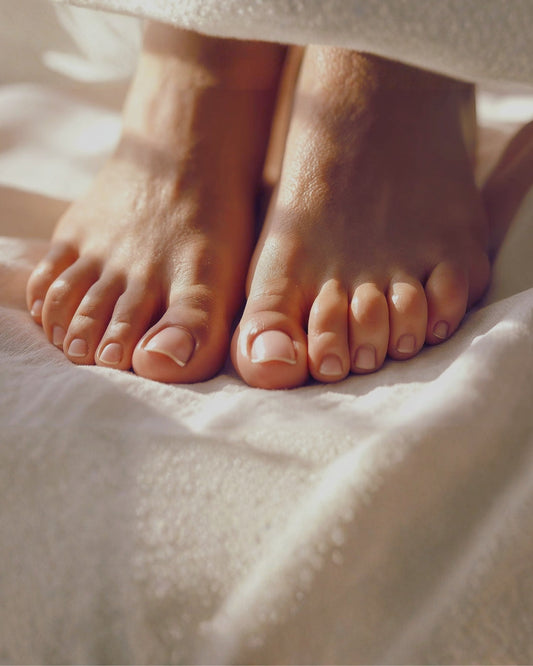 Healthy feet and toenails sitting on a cotton blanket
